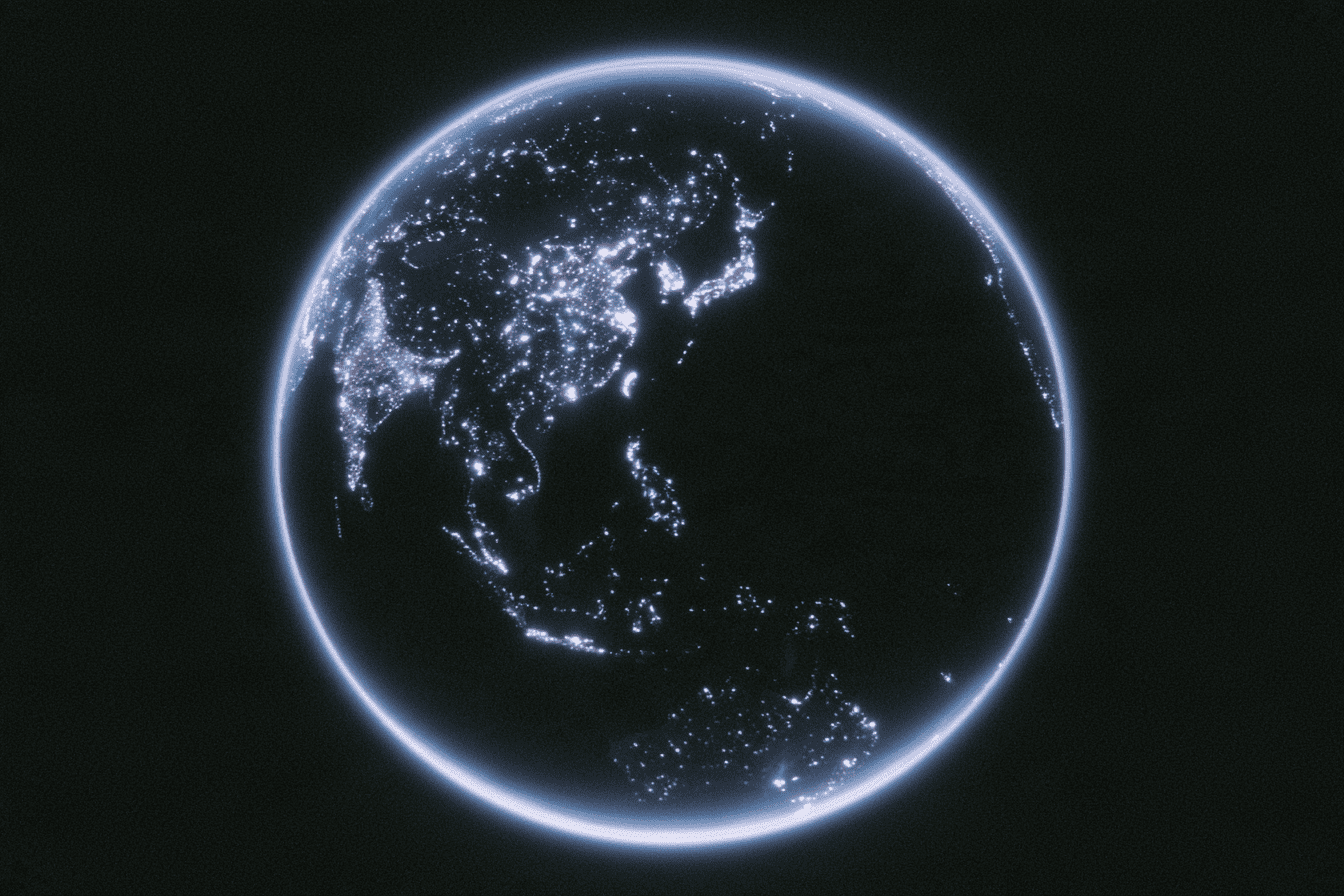 Earth seen from space at night, its outline glowing blue with city lights visible across the surface
